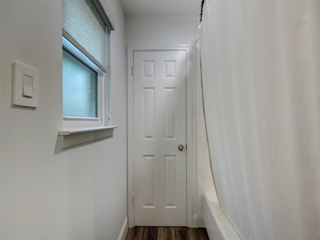 doorway to outside with dark wood-style flooring and baseboards