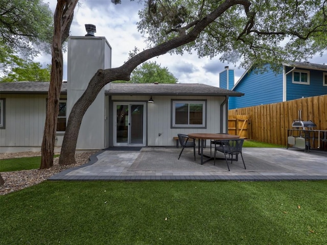 rear view of property featuring a chimney and a patio