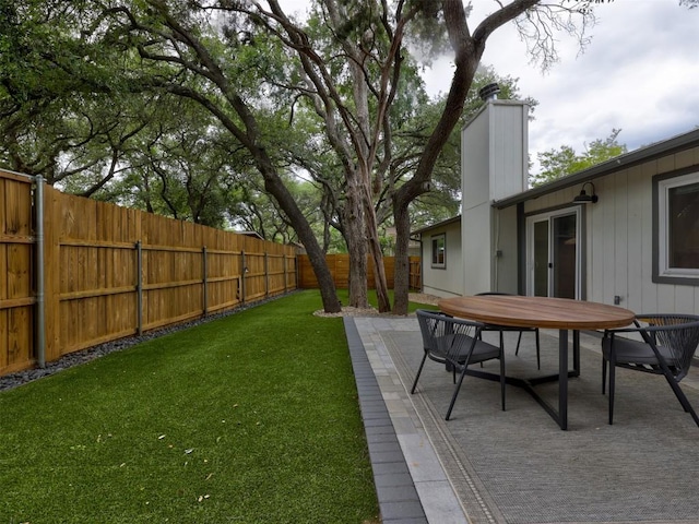 view of yard featuring outdoor dining area and a patio
