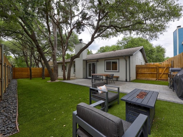 rear view of house with a patio area, an outdoor fire pit, and a chimney