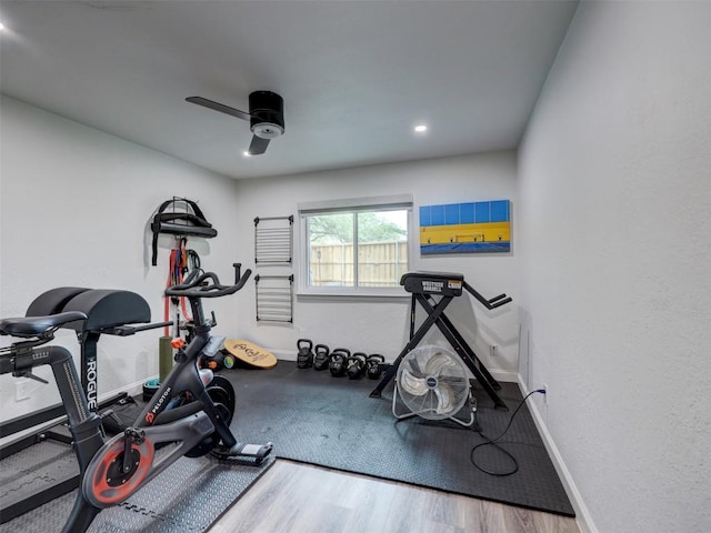 workout room with ceiling fan, baseboards, and wood finished floors