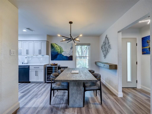 dining area featuring wine cooler, a chandelier, wood finished floors, baseboards, and recessed lighting
