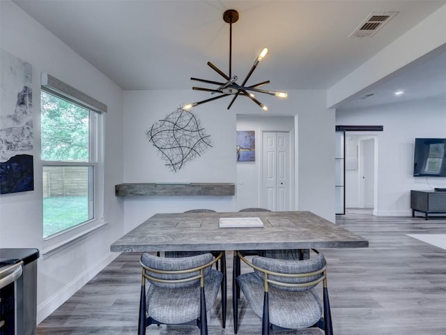 dining area featuring a chandelier, wood finished floors, and baseboards