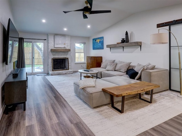 living room featuring healthy amount of natural light, wood finished floors, ceiling fan, vaulted ceiling, and recessed lighting