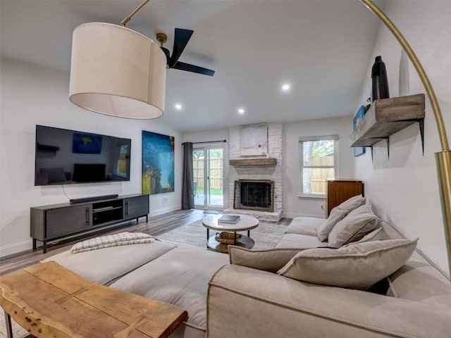 living area with healthy amount of natural light, a fireplace, wood finished floors, recessed lighting, and baseboards