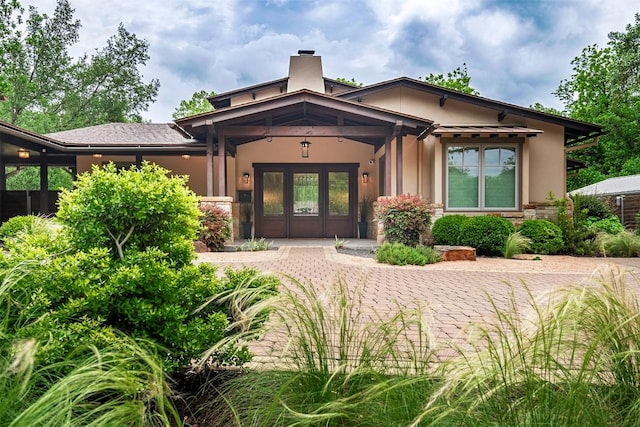 5517 Woodview Ave, Austin, TX 78756 - property entrance featuring a chimney, stucco siding, french doors, and stone siding