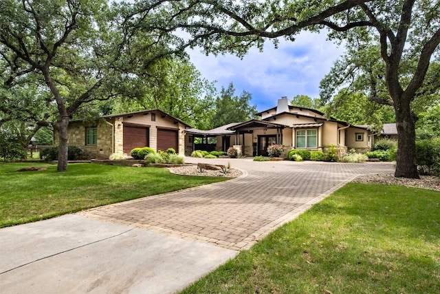 5517 Woodview Ave, Austin, TX 78756 - mid-century modern home with a garage, stone siding, a front yard, decorative driveway, and a chimney