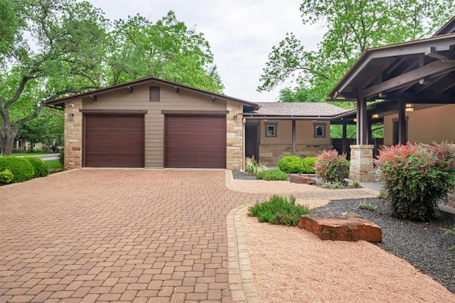 5517 Woodview Ave, Austin, TX 78756 - view of front of house with a garage, decorative driveway, and stone siding