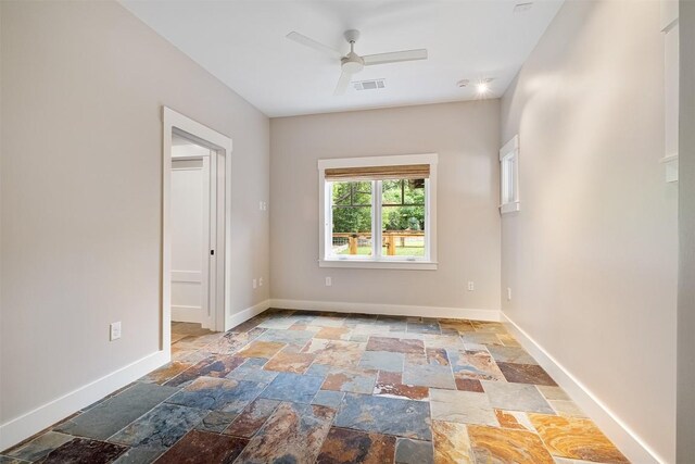 5517 Woodview Ave, Austin, TX 78756 - spare room with baseboards, ceiling fan, visible vents, and stone tile floors