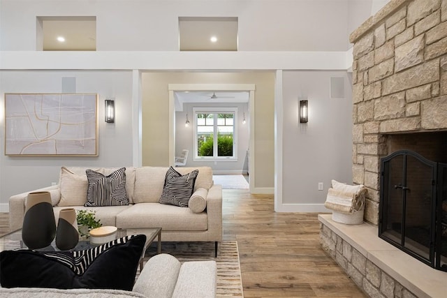 5517 Woodview Ave, Austin, TX 78756 - living area featuring baseboards, ceiling fan, light wood-style flooring, and a stone fireplace