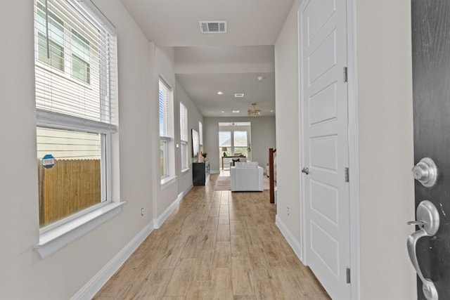 hall featuring baseboards, recessed lighting, light wood-style flooring, and visible vents