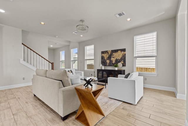 living area with light wood finished floors, recessed lighting, baseboards, visible vents, and stairway