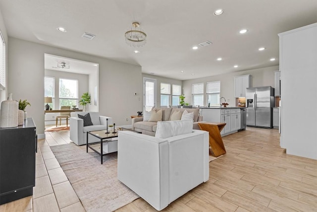 living area featuring recessed lighting, light wood-style flooring, and visible vents