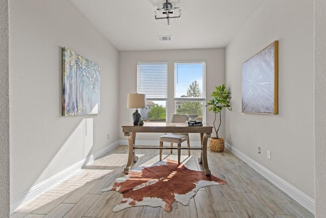 home office featuring visible vents, baseboards, and wood finished floors