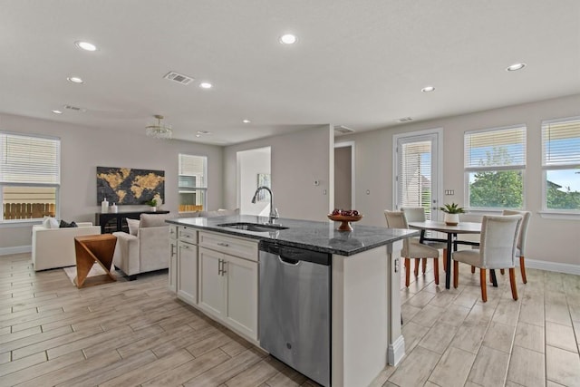kitchen featuring stainless steel dishwasher, visible vents, wood tiled floor, a sink, and a wealth of natural light
