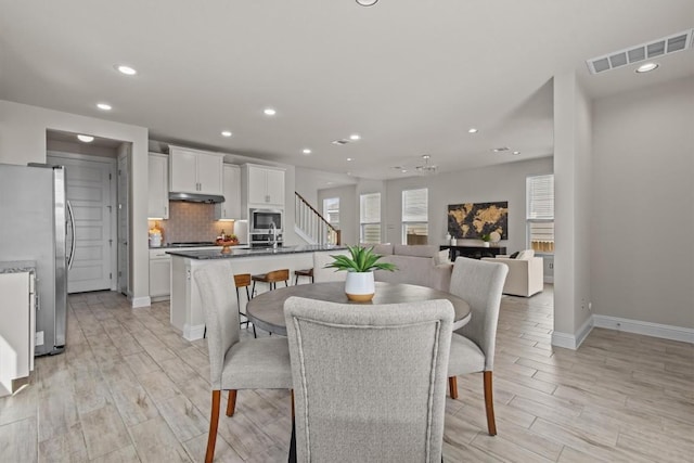 dining space with visible vents, baseboards, stairway, recessed lighting, and light wood-style flooring