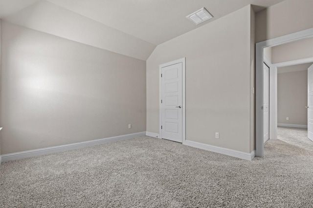 unfurnished bedroom with baseboards, carpet, vaulted ceiling, and visible vents