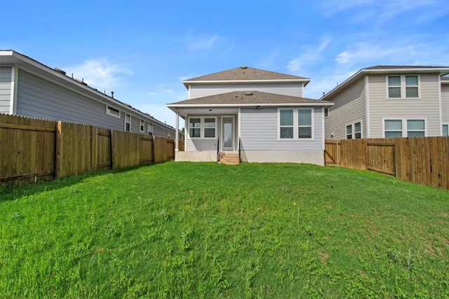 rear view of house with a yard, a fenced backyard, and entry steps