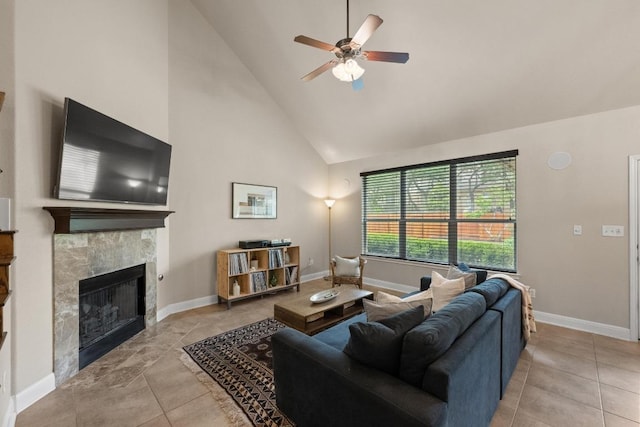 living room featuring high vaulted ceiling, ceiling fan, a fireplace, and baseboards