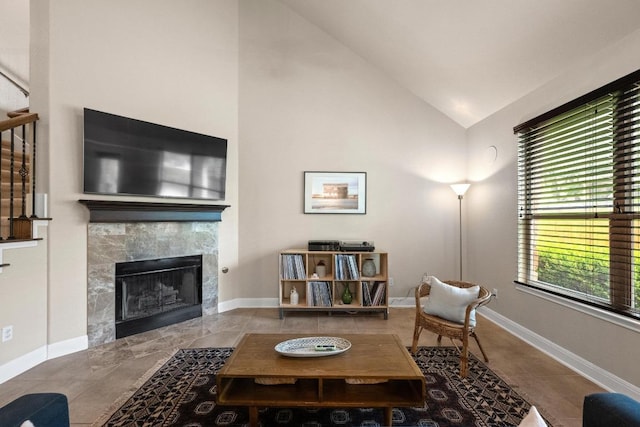 tiled living room featuring baseboards, vaulted ceiling, and a fireplace