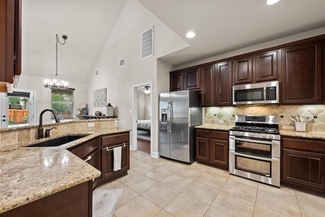 kitchen featuring visible vents, light tile patterned flooring, tasteful backsplash, a sink, and stainless steel appliances