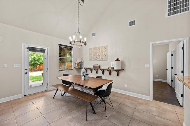 dining space featuring a notable chandelier, visible vents, and high vaulted ceiling