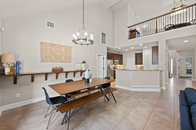 dining room featuring high vaulted ceiling, visible vents, light tile patterned floors, and an inviting chandelier