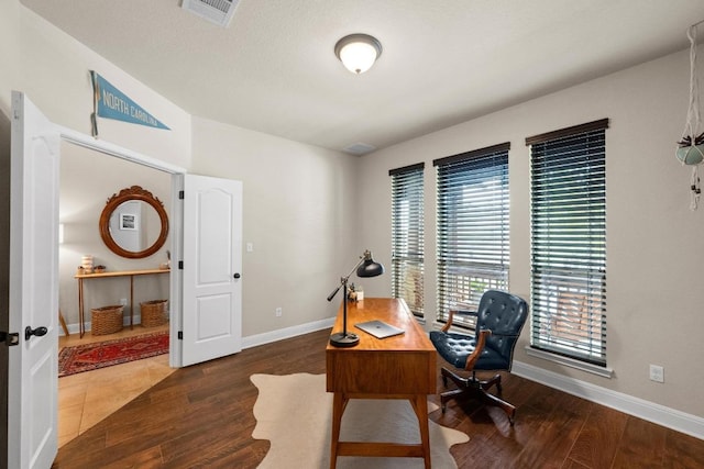 office featuring visible vents, baseboards, and wood finished floors