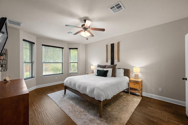 bedroom featuring baseboards, visible vents, multiple windows, and dark wood-type flooring