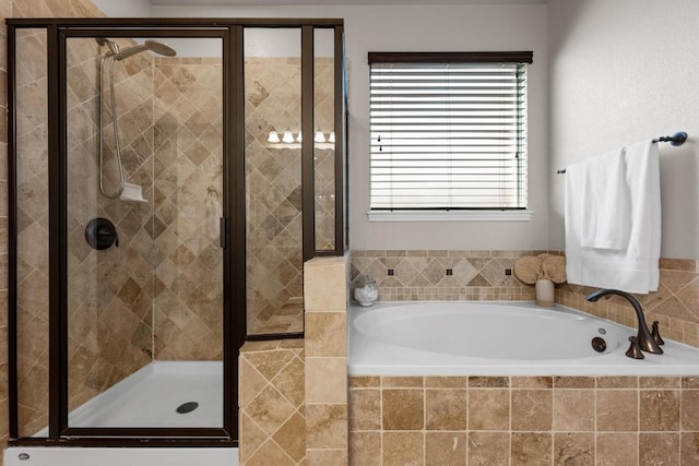 bathroom featuring a shower stall and a bath
