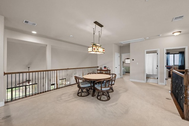 dining area featuring visible vents, attic access, baseboards, and light colored carpet