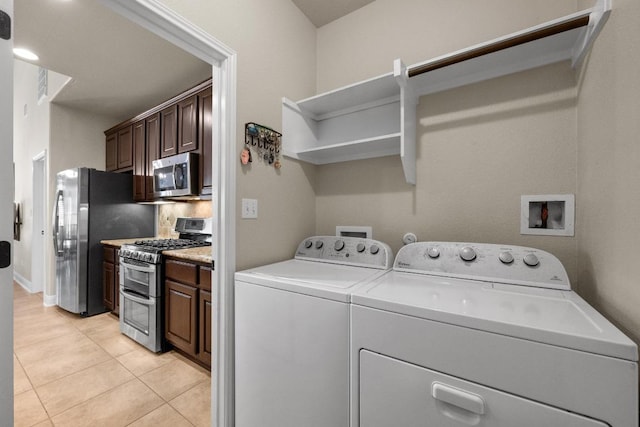 laundry room featuring washing machine and clothes dryer, laundry area, and light tile patterned floors