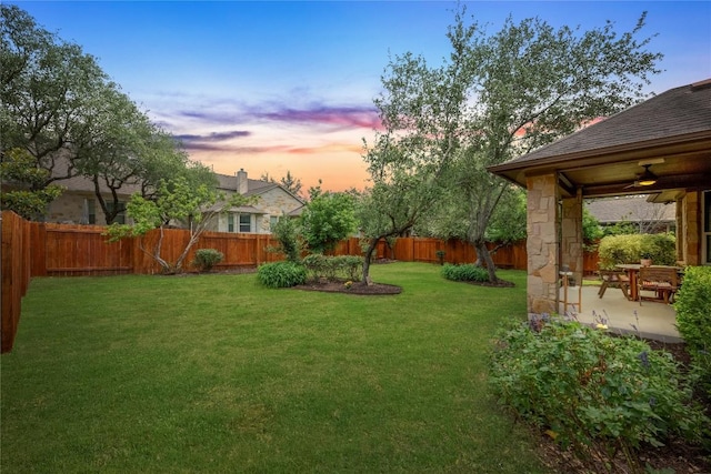 view of yard featuring a fenced backyard, a ceiling fan, and a patio