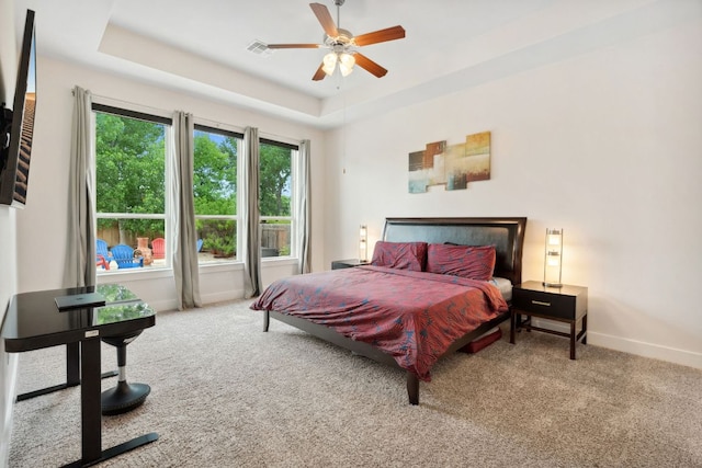 bedroom featuring visible vents, baseboards, ceiling fan, a raised ceiling, and carpet
