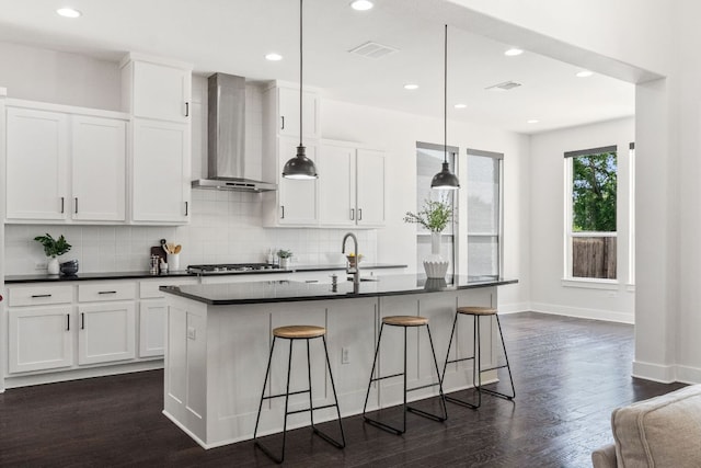 14108 Laurinburg Dr, Austin, TX 78717 - kitchen with wall chimney range hood, dark countertops, backsplash, dark wood-style flooring, and white cabinetry