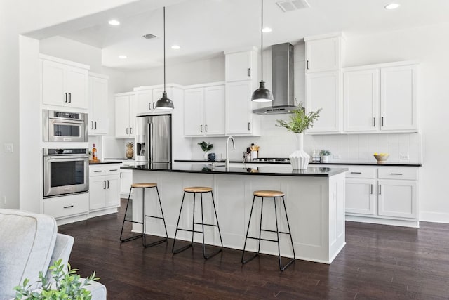 14108 Laurinburg Dr, Austin, TX 78717 - kitchen featuring appliances with stainless steel finishes, wall chimney range hood, dark countertops, dark wood-type flooring, and recessed lighting