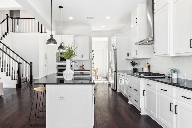 14108 Laurinburg Dr, Austin, TX 78717 - kitchen featuring wall chimney exhaust hood, appliances with stainless steel finishes, dark countertops, dark wood-style flooring, and decorative backsplash