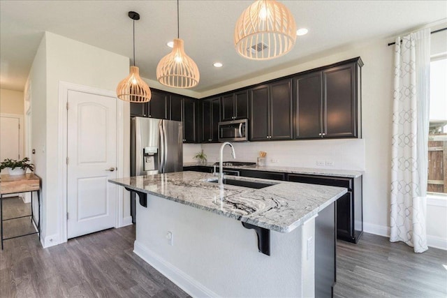 3209 Maysillee St, Austin, TX 78728 - kitchen with baseboards, dark wood-style flooring, appliances with stainless steel finishes, and light stone countertops
