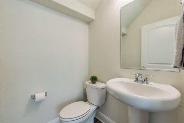 bathroom with toilet, baseboards, and a sink