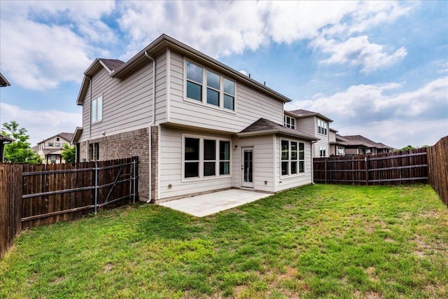 rear view of property featuring a patio, a fenced backyard, a yard, and brick siding