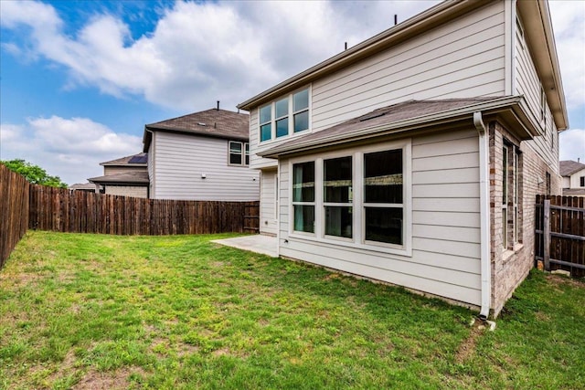 back of property featuring a fenced backyard and a yard
