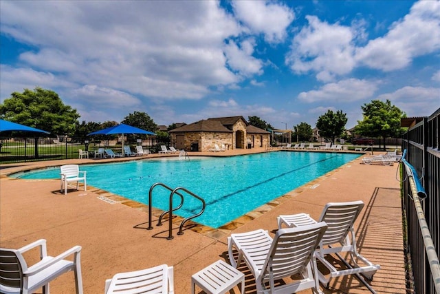 pool with fence and a patio area