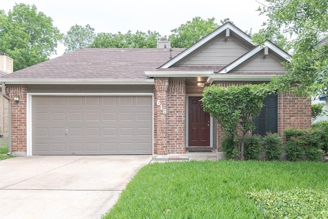view of front facade with driveway, a chimney, roof with shingles, a garage, and brick siding
