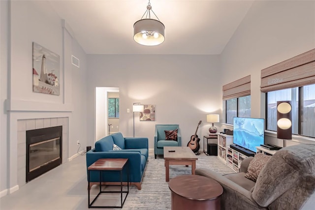 living area featuring baseboards, visible vents, and a fireplace