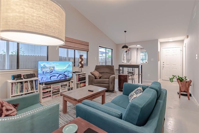 living room featuring baseboards, arched walkways, and lofted ceiling