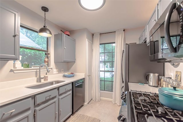 kitchen featuring a sink, light countertops, gray cabinetry, and stainless steel appliances