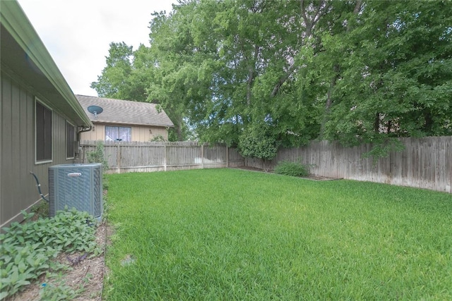 view of yard with a fenced backyard and central AC unit