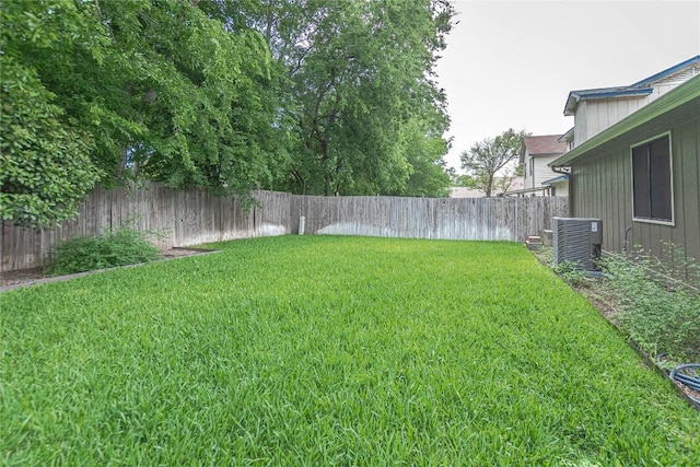 view of yard with central AC and a fenced backyard