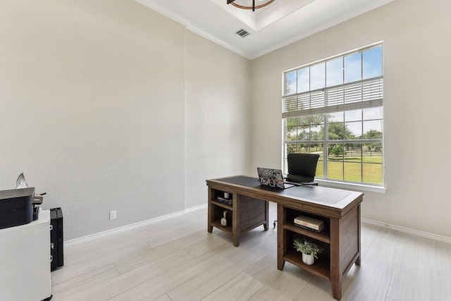 office area with baseboards, ornamental molding, light wood finished floors, and visible vents