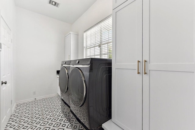 clothes washing area featuring independent washer and dryer, baseboards, visible vents, and cabinet space